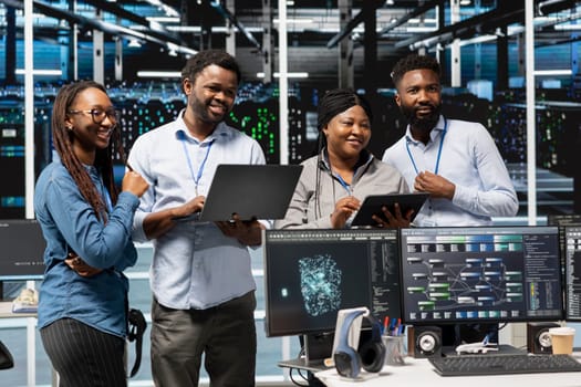 Cheerful data center experts working together, using deep learning algorithms and node trees to analyze datasets. Jolly server farm teamworking colleagues using AI to recognize facility data patterns