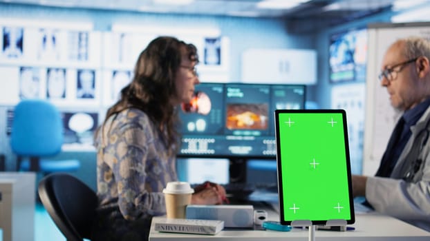 Old general practitioner consulting a female patient next to chroma key space, discussing about important medicine. Physician offers professional advice and suggestions for treatment. Camera A.