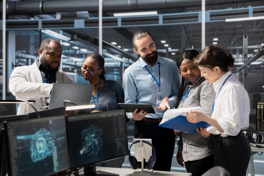 Engineering team working together in data center with artificial intelligence neural networks tech. Server farm staff members cooperating, using AI programming language to update equipment