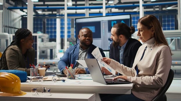 Factory research and development scientists use laptop to test materials for next generation solar panels. Industrial plant researchers work on breakthroughs in durability and performance, camera A