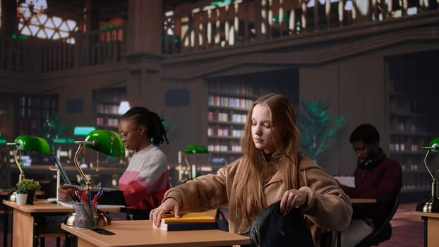 Female college student reads and writes detailed notes for a new course, studying political science for upcoming lecture in a library setting at university. Girl consults database. Camera B.