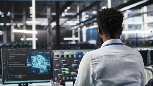 Server hub programmer using AI machine learning node tree software to optimize system health. Data center IT expert analyzing equipment issues using artificial intelligence visualization, camera B