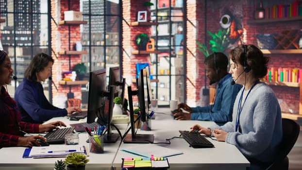 Call center agent helping customers regain access to accounts, resetting passwords. Employee in customer center workspace assisting clients needing help, providing helpful solutions, camera B