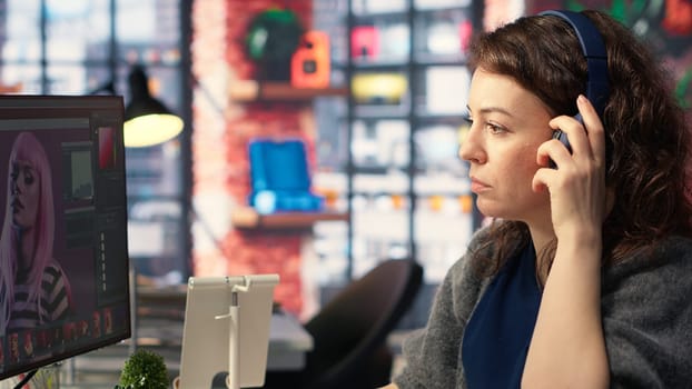 Woman expert developer works with photo editing software in the creative workspace, digital media. Using dual monitors to ensure productivity and innovation in the graphic design world. Camera B.
