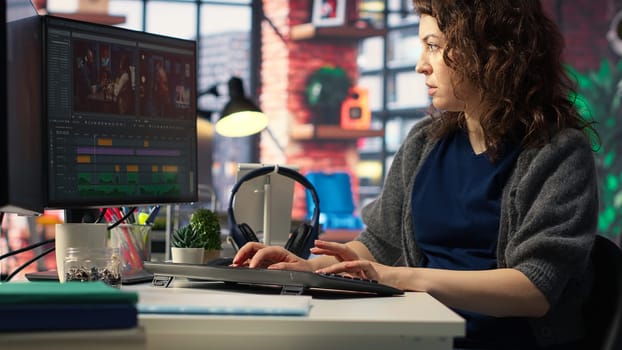 Woman video creator working on editing a movie montage project, multitasking with dual monitors. Female footage editor starting the cinematic creative process, film editing industry. Camera B.