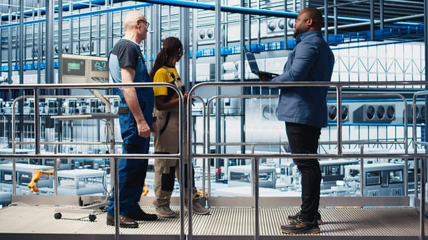 Investor visiting industry 4.0 solar panels plant, talking with engineers to ensure limited downtime before investing. Photovoltaics smart factory shareholder checks work done by technicians, camera A