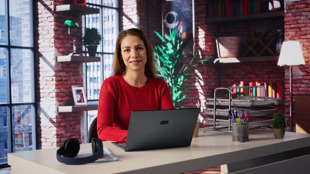 Confident woman solving her tasks on a freelance platform at home, answering emails and multitasking. Mature worker staying connected and enjoying the flexibility of working remotely. Camera B.