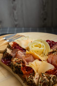 Food trend gift aperitivo party idea. Appetizers wooden grazing board with different antipasti charcuterie snacks and cheese. Assorted cheese meat platter. Disordered eating. Girl dinner