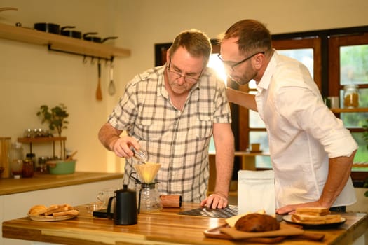 Senior man and son brewing fresh coffee together during a cozy morning at home. Father day concept.