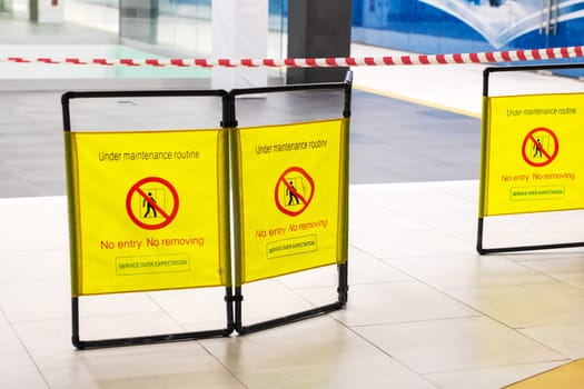 A bright yellow sign displaying the words No Entry prominently written on it, indicating restricted access in a particular area