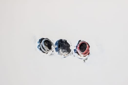 This is a minimalist image that depicts three circular holes on a textured wall, emphasizing both form and color
