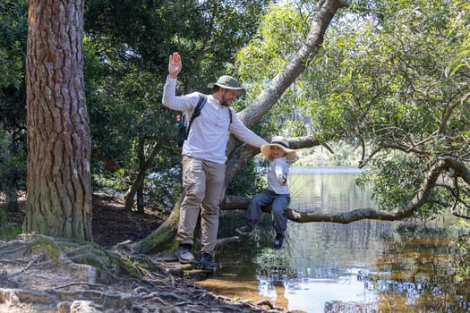 Father and son enjoying a sunny day by the lake, exploring nature and creating memories together