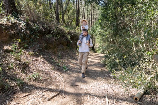 Father and son enjoying a hike in the woods, promoting family bonding and outdoor activities