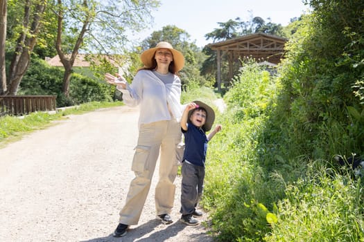 Mother and son wearing hats and smiling enjoying a sunny day on a country road