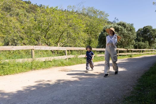 Mother and son enjoying a leisurely walk on a sunny summer day in the countryside