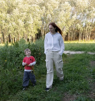 Mother and son enjoying a leisurely stroll through nature, fostering connection and creating cherished memories