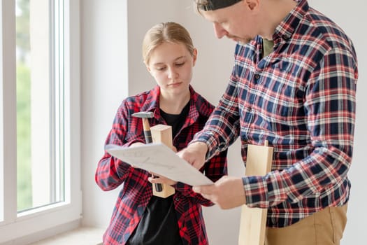 Dad And Daughter Looking At Furniture Assembly Diagram At Home