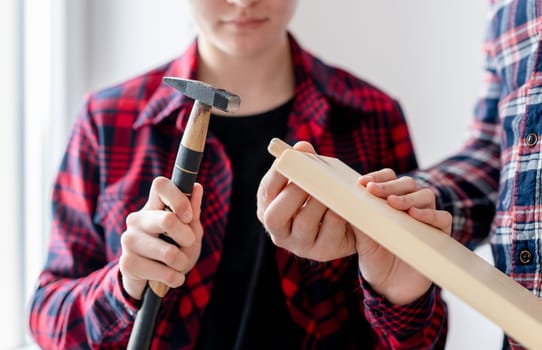 Girl And Dad Hammer Dowels Into Board In Close-Up