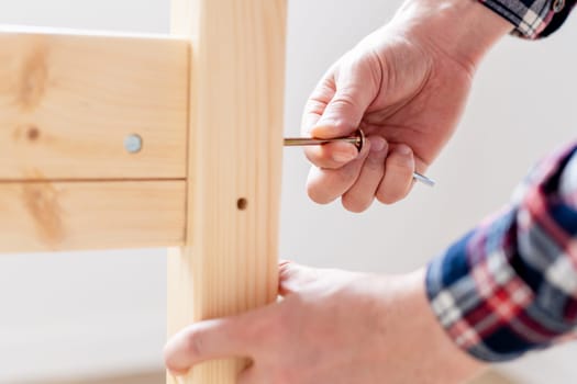 Man Assembling Bed On The Floor At Home
