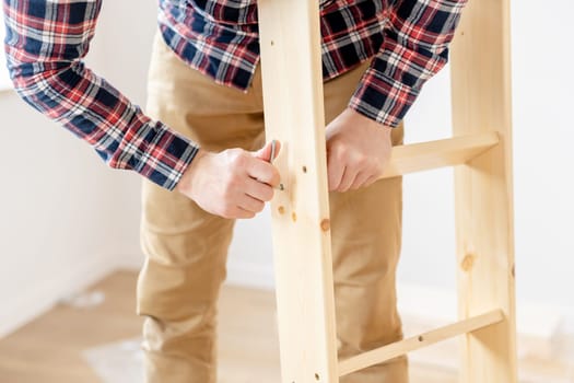 Man Assembling Bed On The Floor At Home