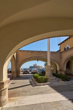 Rodas.Greece - june 05, 2025: Arched passage at the old governors palace, framing the distant castle under a clear sky. Sunlight illuminates the stone, atmosphere of antiquity and tranquility.