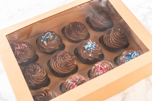 Preparing to share the delicious chocolate cupcakes, the final step involves carefully packaging them into a brown paper cupcake box.