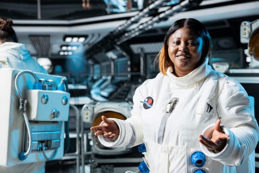 Portrait of cheerful female astronaut in futuristic spacecraft navigating orbital trajectory. Jolly woman in spaceship conducting safety checks during planetary exploration