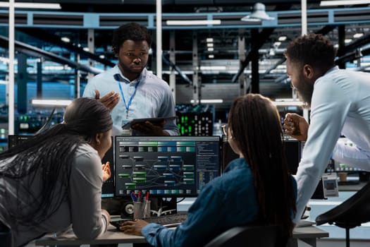 Data center system administrators using PC to visualize artificial intelligence neural networks made up of interconnected nodes. Server farm coworkers doing brainstorming, overseeing AI systems