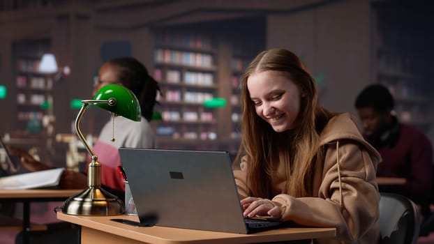 Young scholar celebrating some good news and feeling pleased with progress, finishing a school project for a high grade. Student passing her exams, peaceful campus library. Camera A.