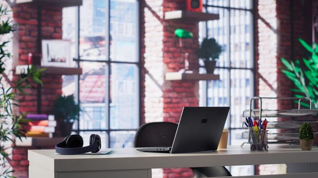 Empty desk in a luxurious loft apartment with a modern minimalist design. Bright spacious home office features sleek furniture, panoramic windows and an elegant ambiance perfect for creativity.