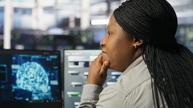 Data center computer scientist using artificial intelligence deep learning models to configure hardware. IT specialist using AI programming languages on PC in server farm, optimizing system, camera B