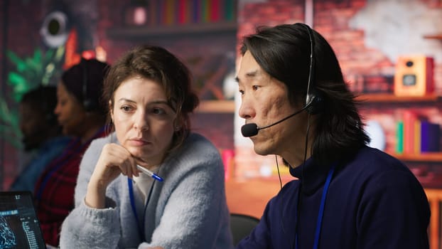 Call center team leader supervising agent helping customers regain access to accounts and devices. Customer center manager overseeing intern assisting clients needing help resetting password, camera A