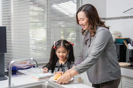 A mother and her daughter work together to prepare food, fostering teamwork and connection in a bright kitchen.