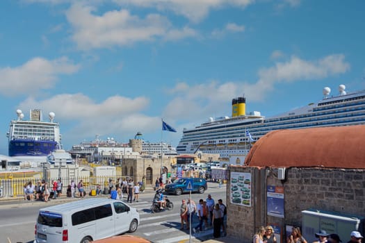 Rodas.Greece - june 05, 2025: A busy day at Rhodes port, where imposing cruise ships dominate the skyline as tourists and locals move along the bustling waterfront. The dynamism of visitor arrivals.