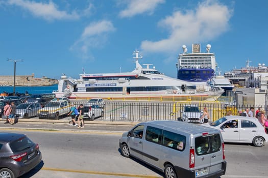 Rodas.Greece - june 05, 2025: The bustling cruise terminal in Rhodes, featuring multiple passenger ships and the activity of tourists and vehicles. A sunny day highlights the vibrant atmosphere of the port city.