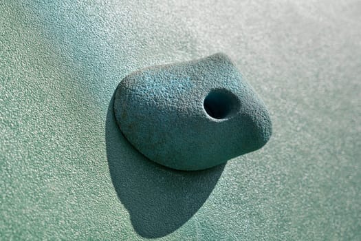 An artificial blue climbing hold on a wall. Close up macro