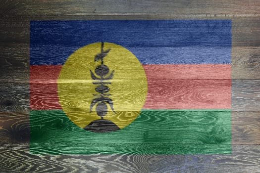 A New Caledonia flag on rustic old wood surface background