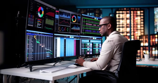 Business Analyst Studying Financial Charts On Late Night Computer Monitor