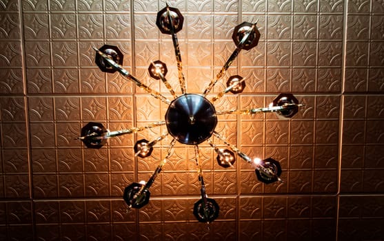View of a Light Fixture That is Underneath a Tin Ceiling
