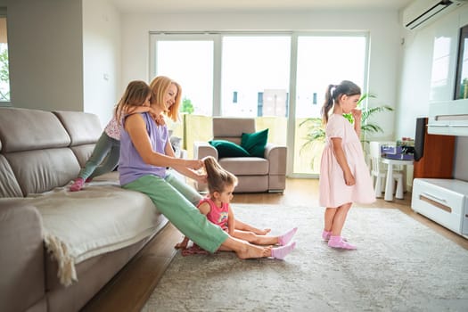 A mother enjoying playful moments with her girls at home
