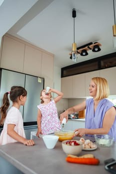A joyful mother and her daughters prepare a treat together.