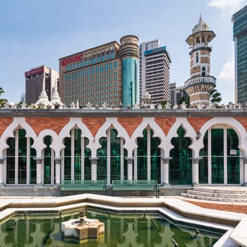Kuala Lumpur, Malaysia - Feb. 17, 2025: Historic Masjid Jamek Sultan Abdul Samad mosque architecture contrasted with modern skyscrapers in downtown