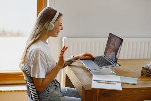 A young woman is connecting with others through a video call, showcasing remote work and digital communication