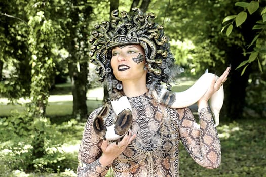A woman dressed as Medusa with a snake around her neck