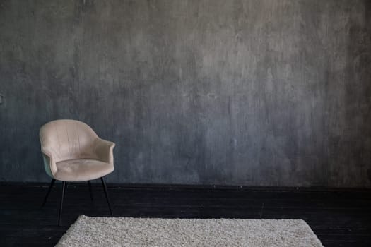 Beige vintage armchair in the interior of a gray room