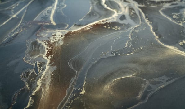 Bold swirls of color flow harmoniously on the textured surface, creating stunning abstract patterns.