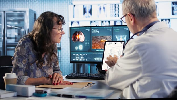 Healthcare professional sharing his expertise and interpreting the MRI scans results, offering advice and support to sick woman at checkup. Accurate diagnostics and patient care. Camera A.
