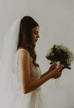 Portrait of a young unrecognizable Caucasian bride with a bouquet of boutonnieres.