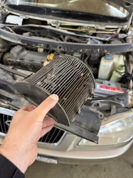 A dirty cabin air filter is replaced in a car