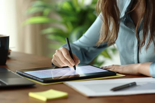 Close up of an employee hands working handwriting on digital tablet at office